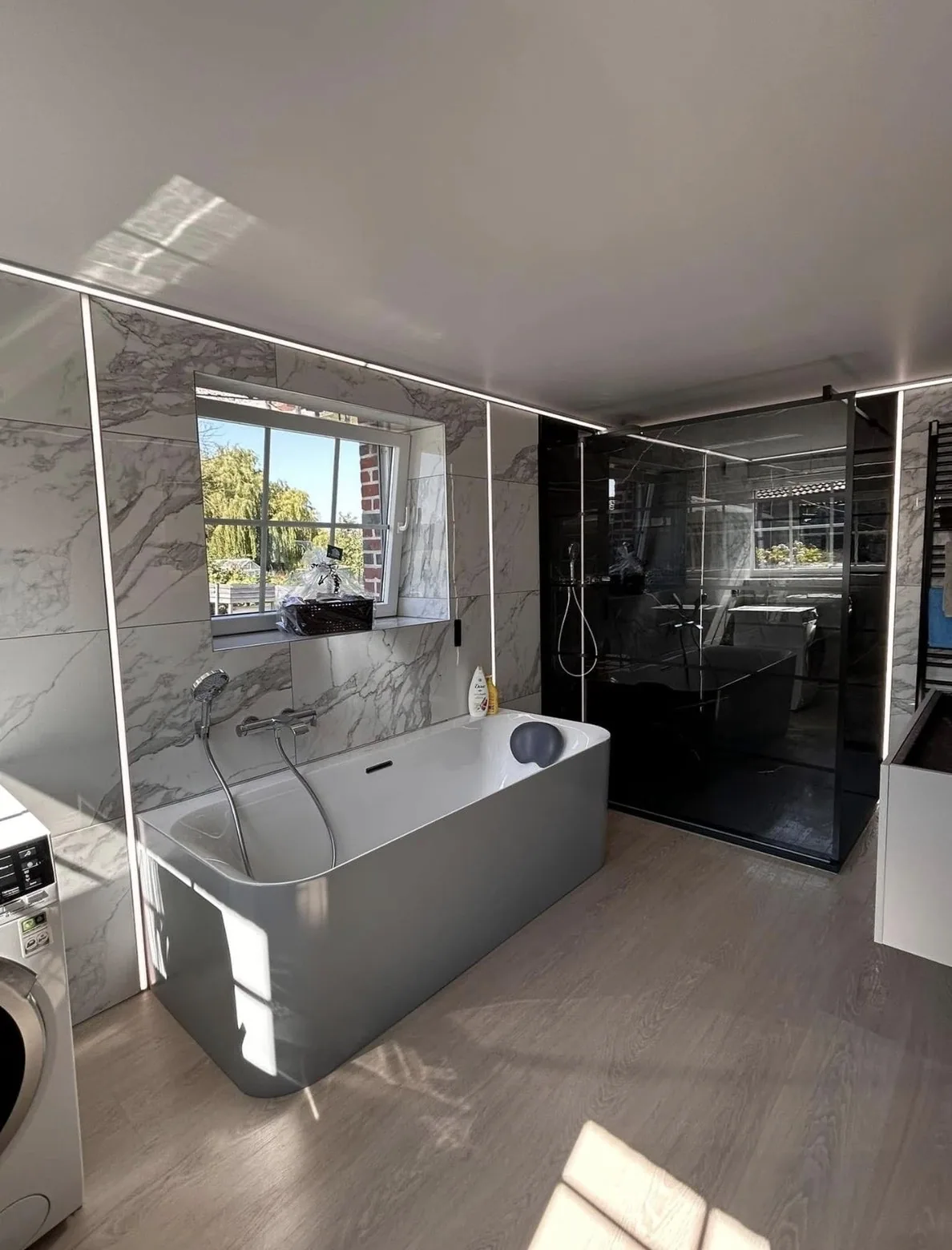 Vue d’ensemble de la salle de bain en marbre avec baignoire et douche