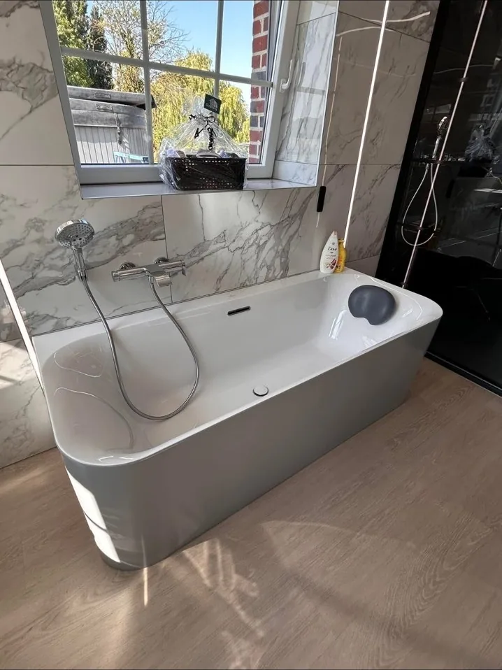 Salle de bain marbre avec baignoire îlot et grande fenêtre