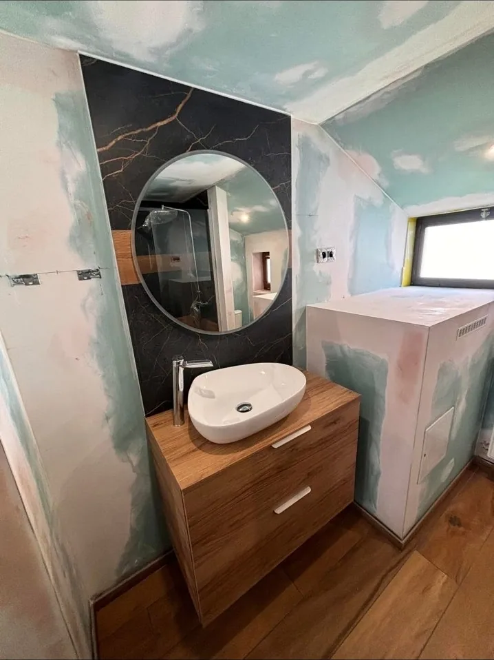 Vasque en pierre et miroir rond après rénovation